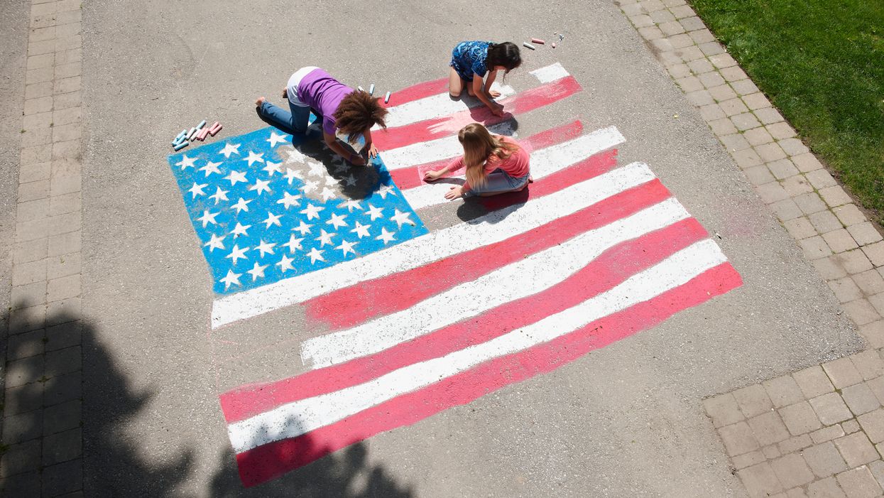Girls coloring an American flag with chalk