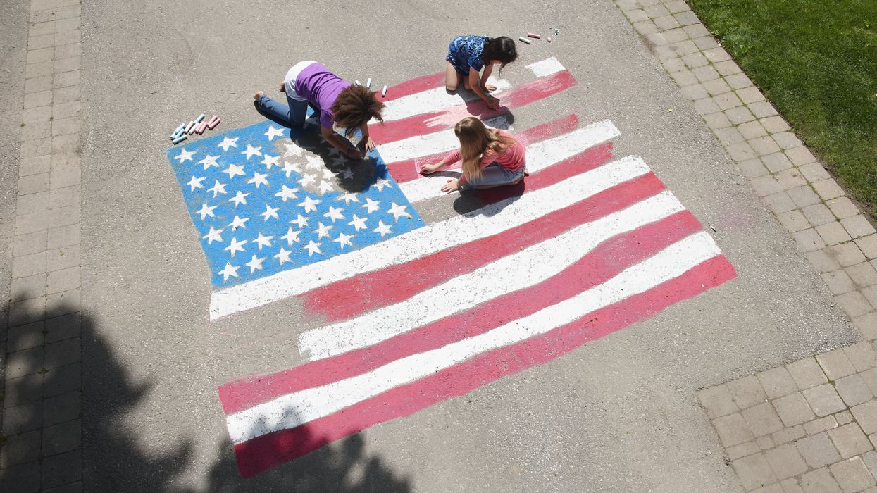 Girls drawing an American flag with chalk