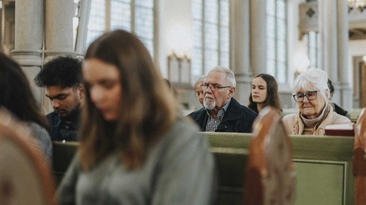 Group of male and female people sitting together during mass at church.