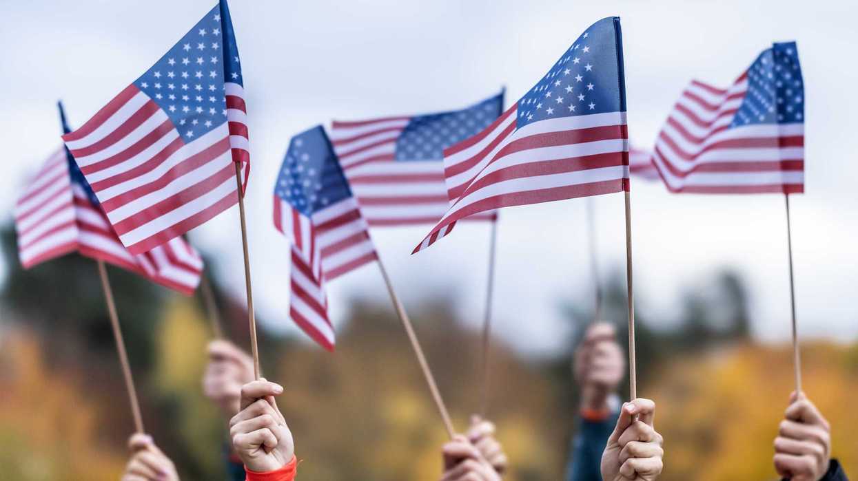 Group of people waving small American flags at sunset. Concept for different topics like Election Results, Happy Veterans Day, Labor Day, Independence Day, President day