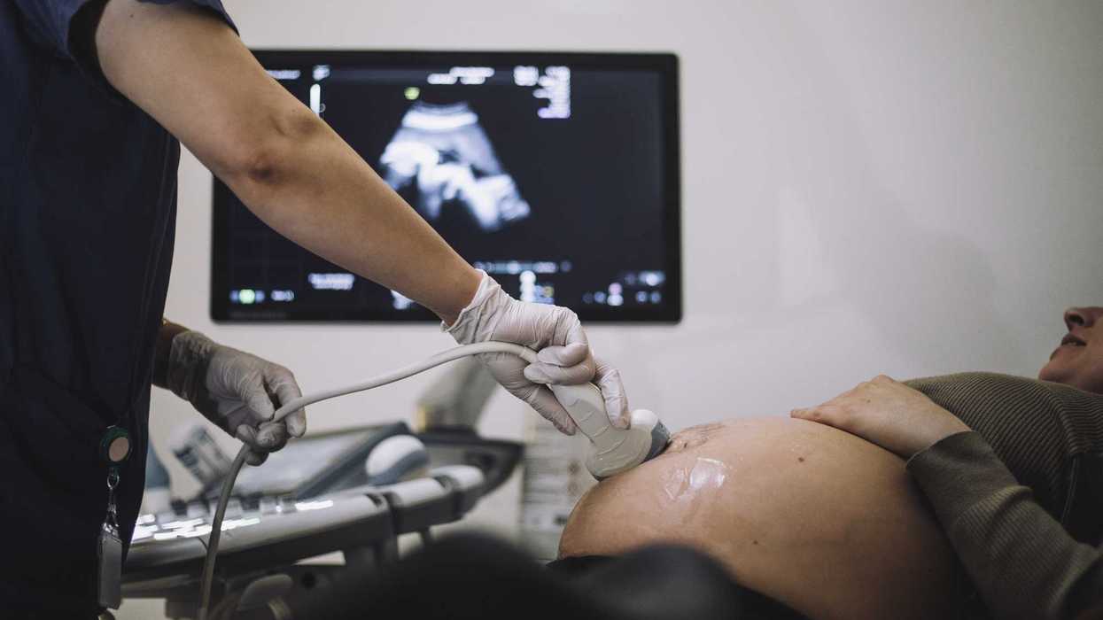 Gynecologist doing ultrasound of pregnant woman in hospital.