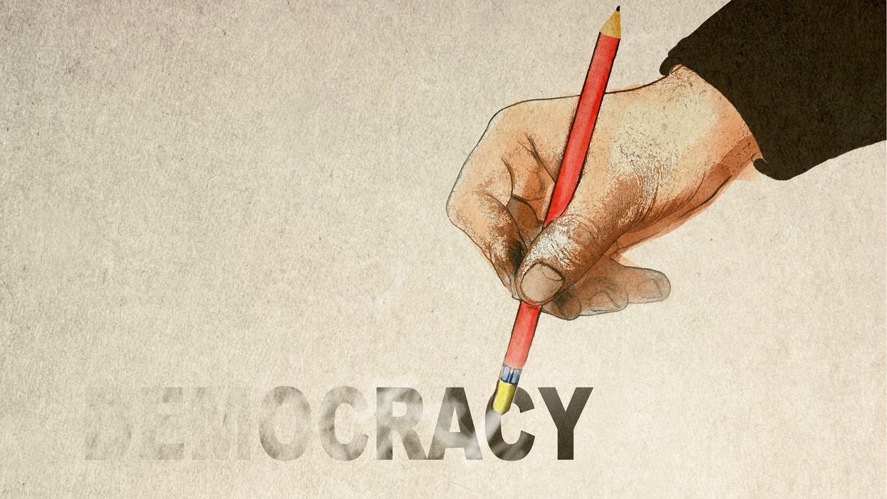 Hand erasing the word "democracy"