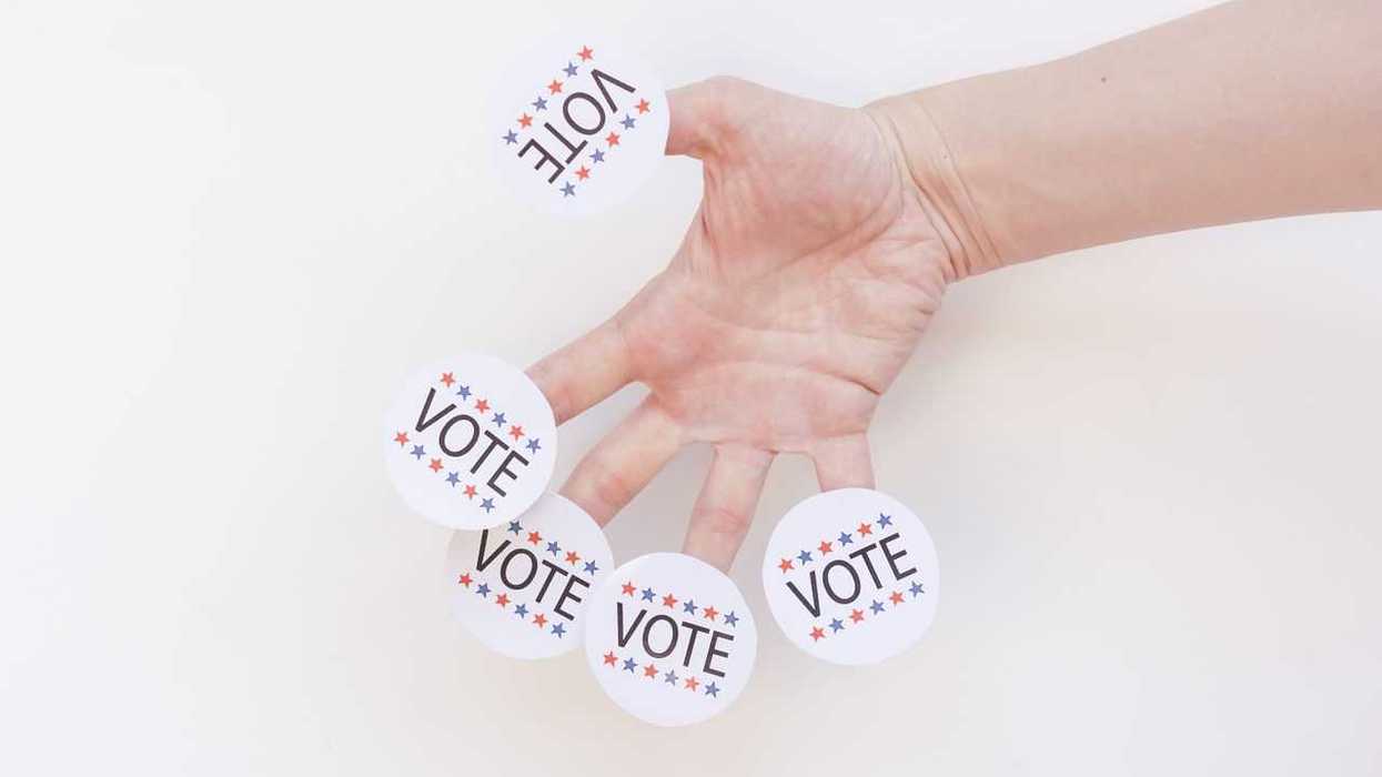Hand with "VOTE" stickers
