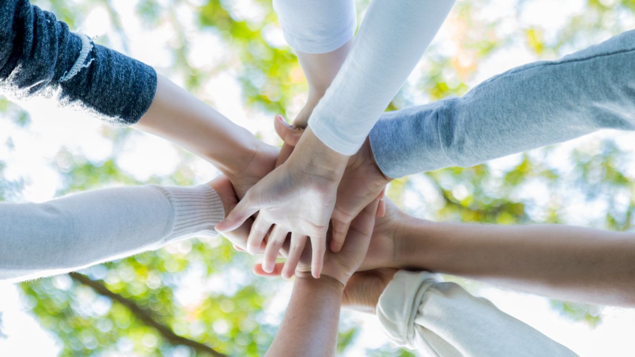 Hands coming together in a circle of people
