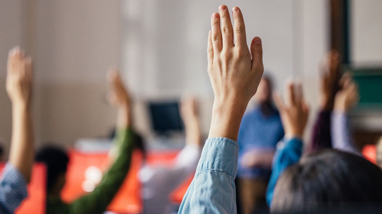 Hands raised in a classroom.