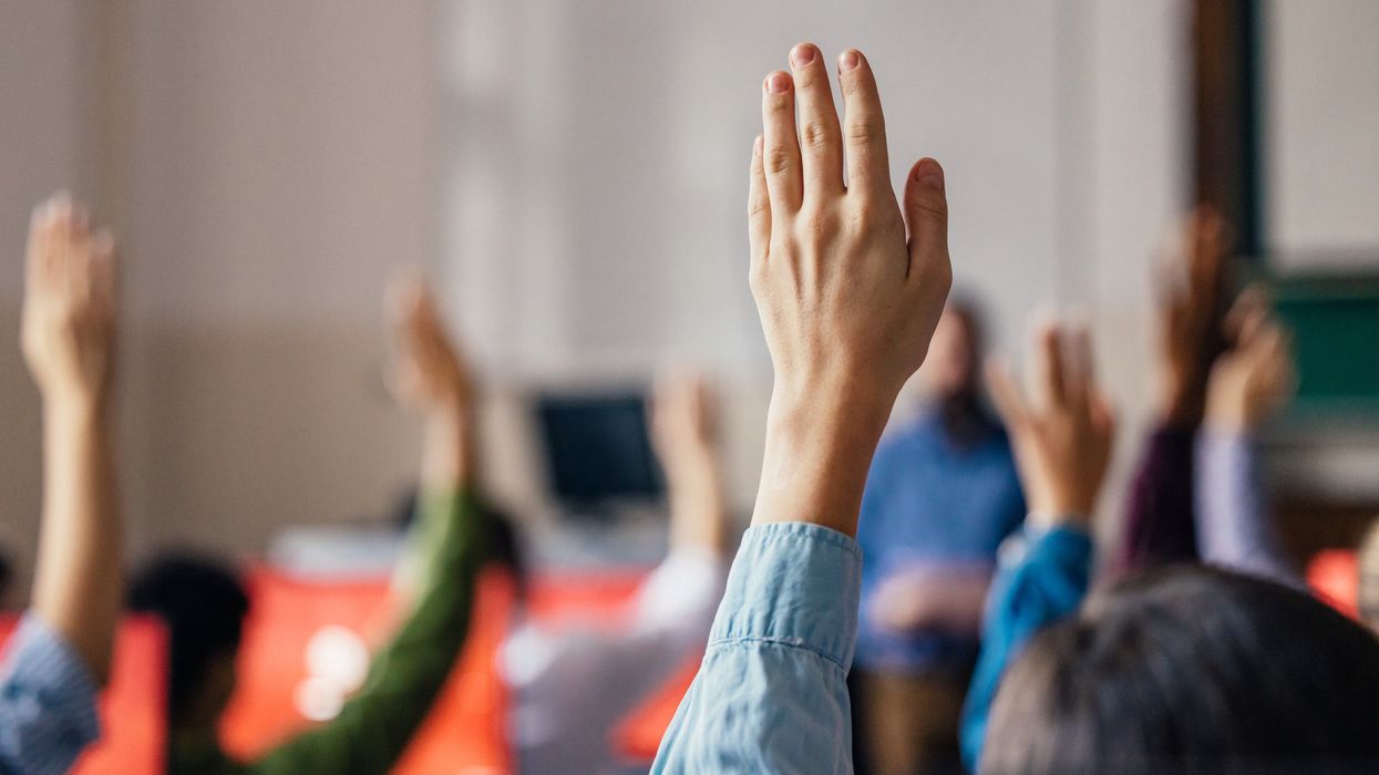 Hands raised in a classroom.