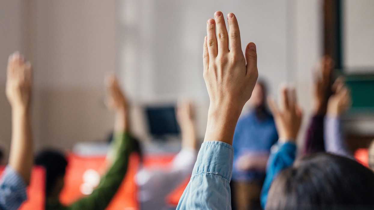 Hands raised in a classroom.