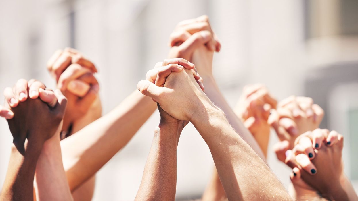 Hands raised in the air, holding each other.