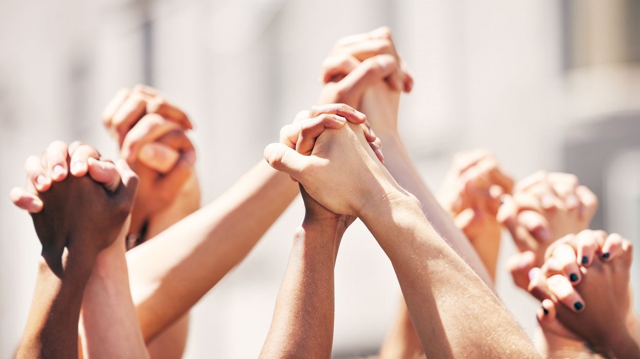 Hands raised in the air, holding each other.