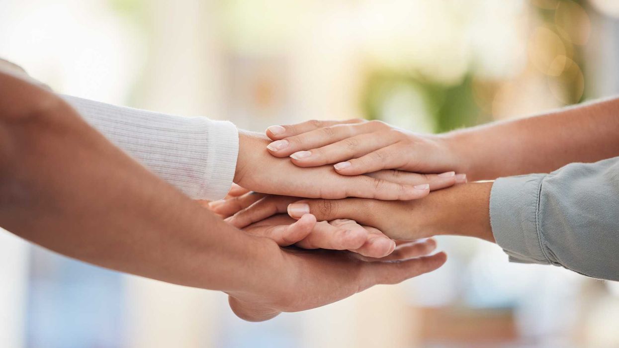 Hands resting on another.