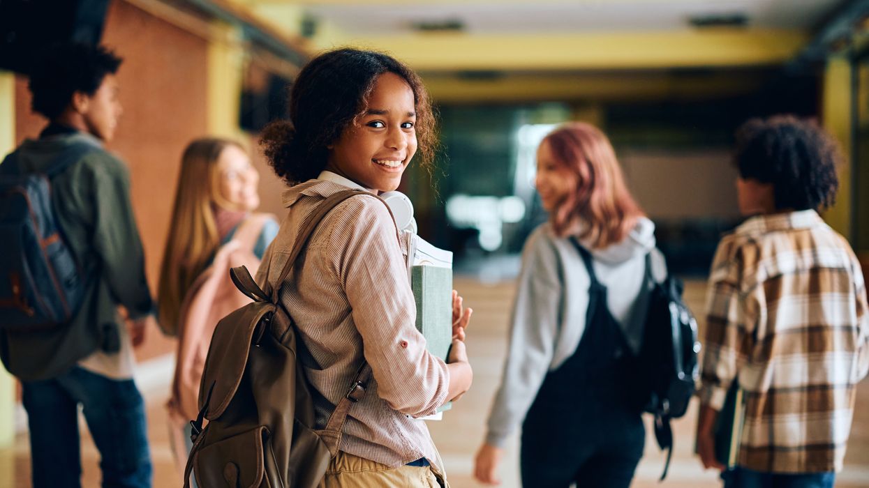 Happy Black teenager girl walking through a school