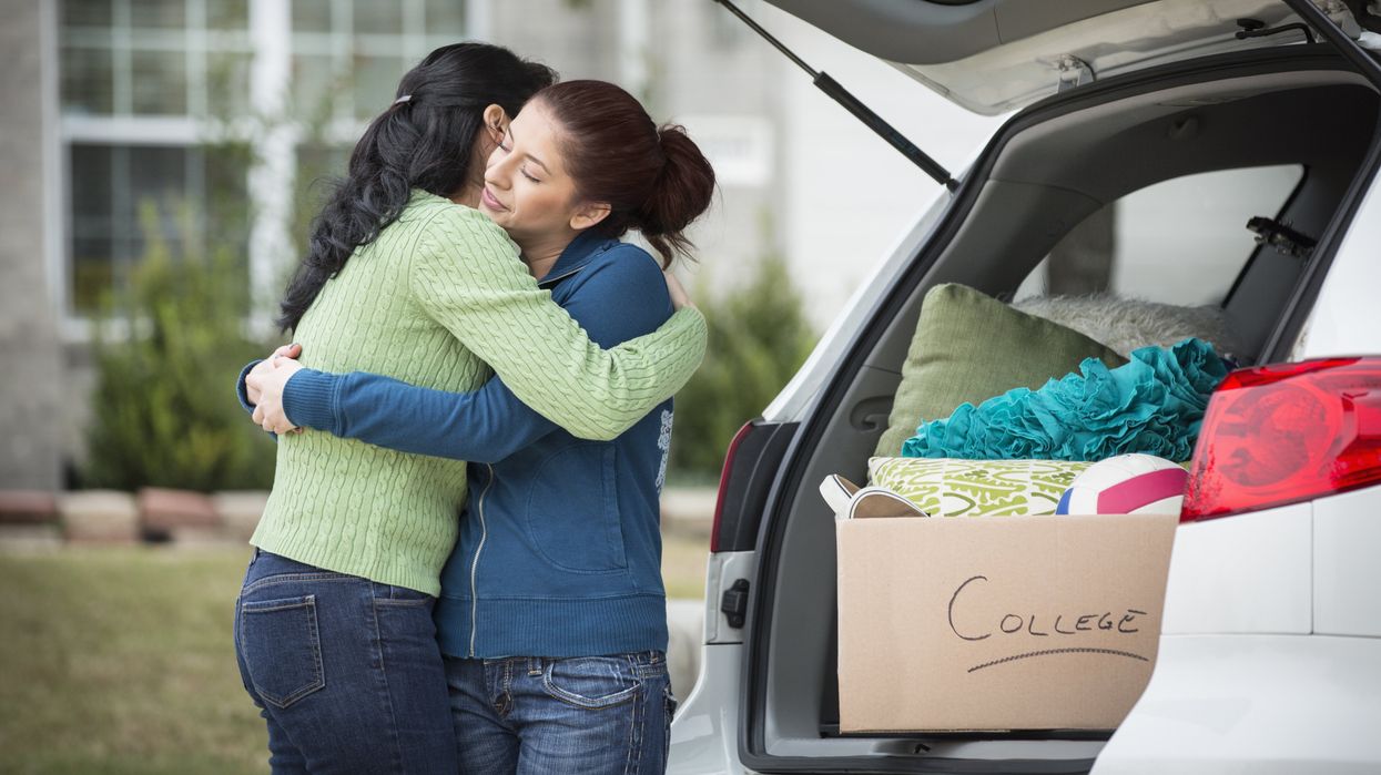 Hispanic mother helping daughter pack for college