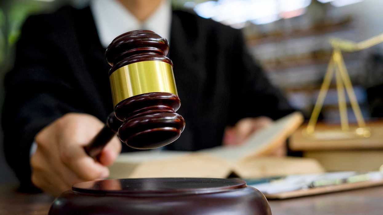 Judge's hand holding wooden hammer