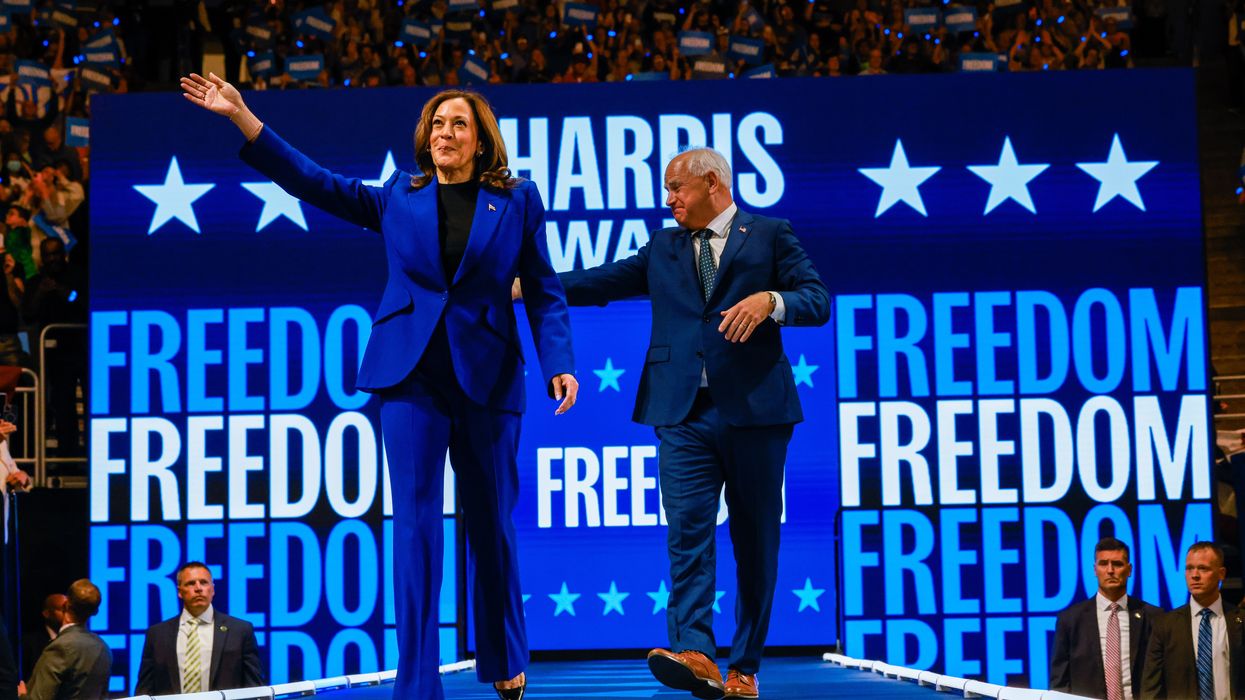 Kamala Harris and Tim Walz walk onto a stage