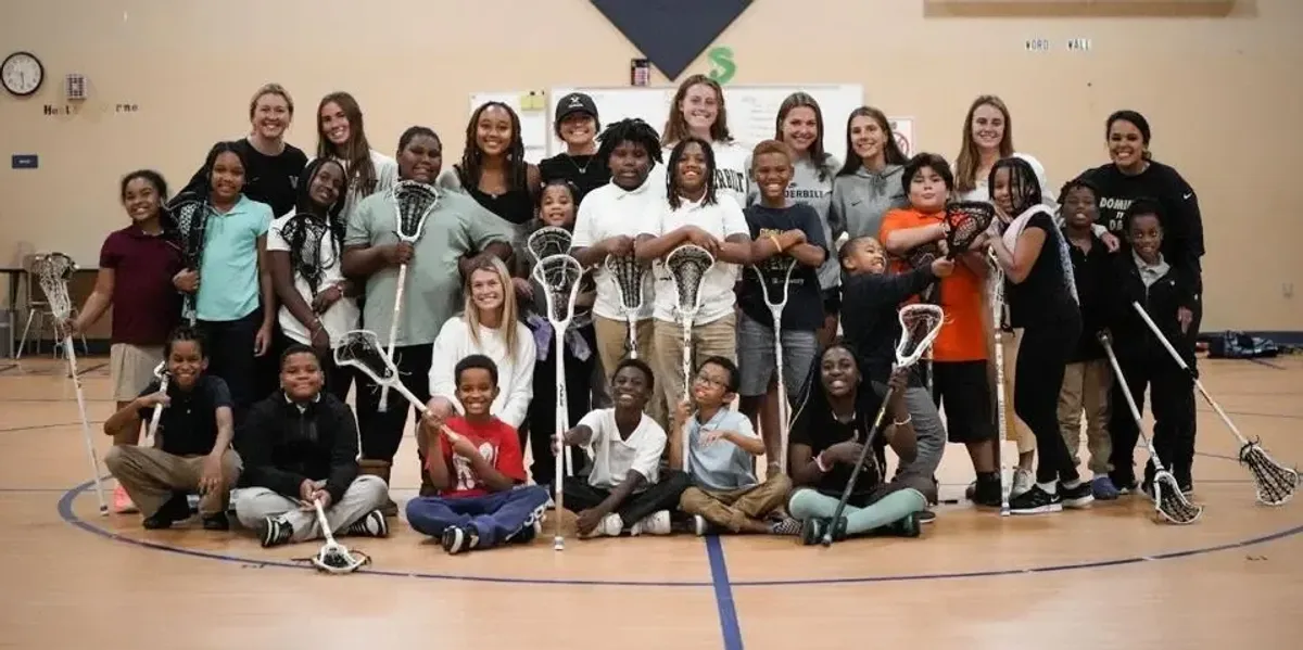 Lacrosse players posing with kids