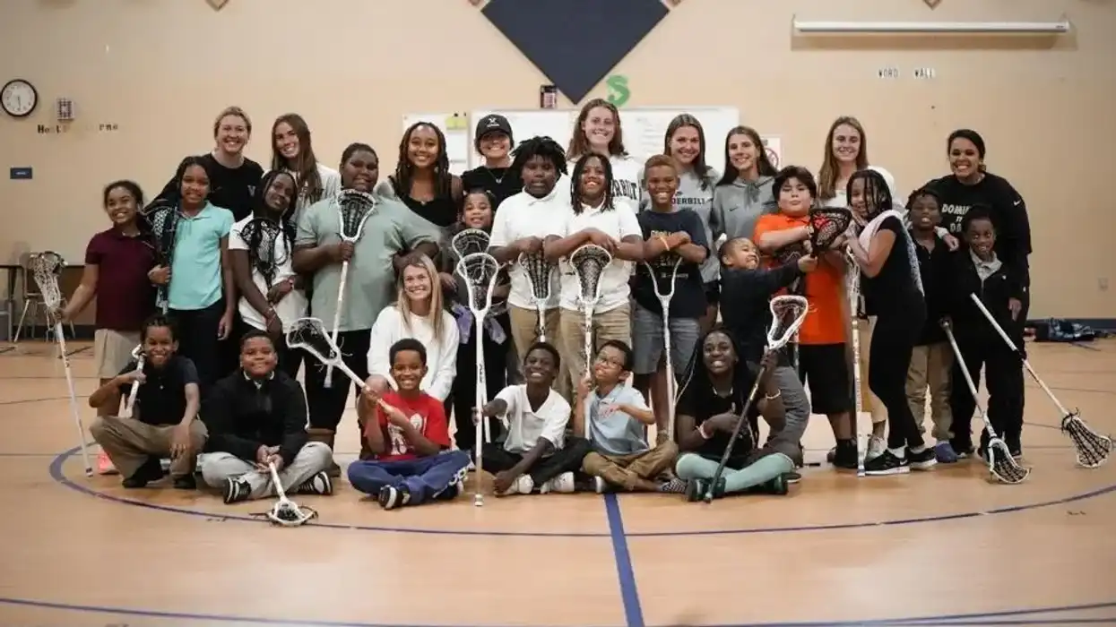 Lacrosse players posing with kids