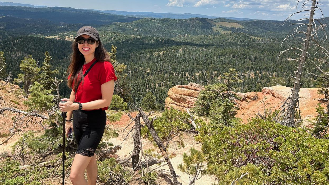 League of Women Voters of Arkansas President Bonnie Miller on a hike, standing in front of a landscape view.