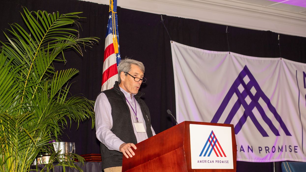 Man at a podium with American Promise logo