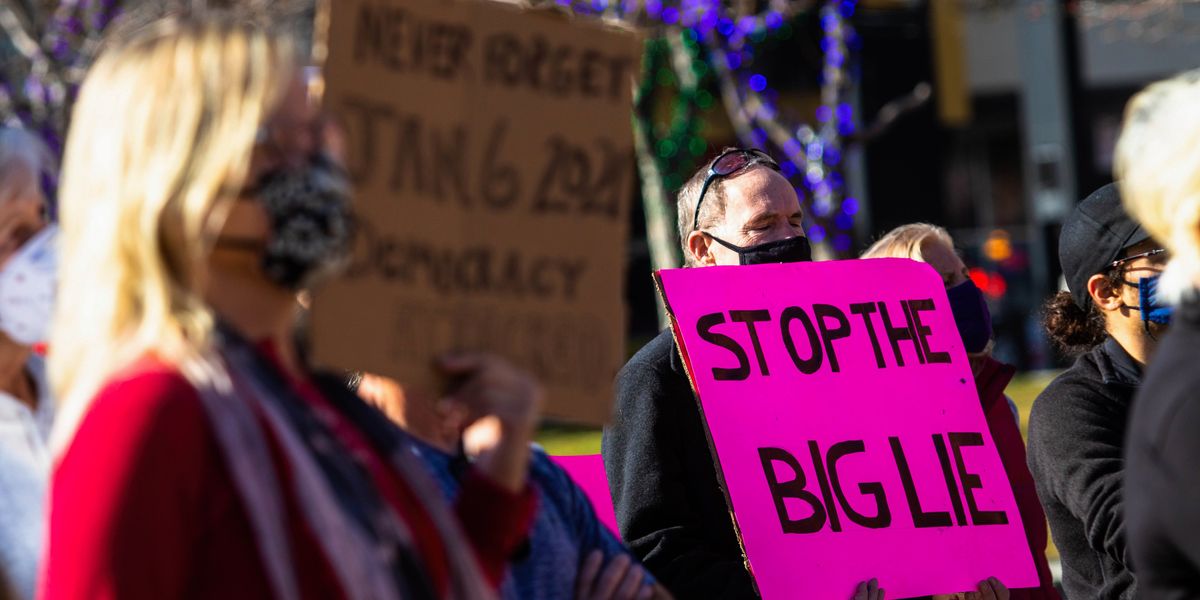 Man holding a sign that reads, "Stop the Big Lie"