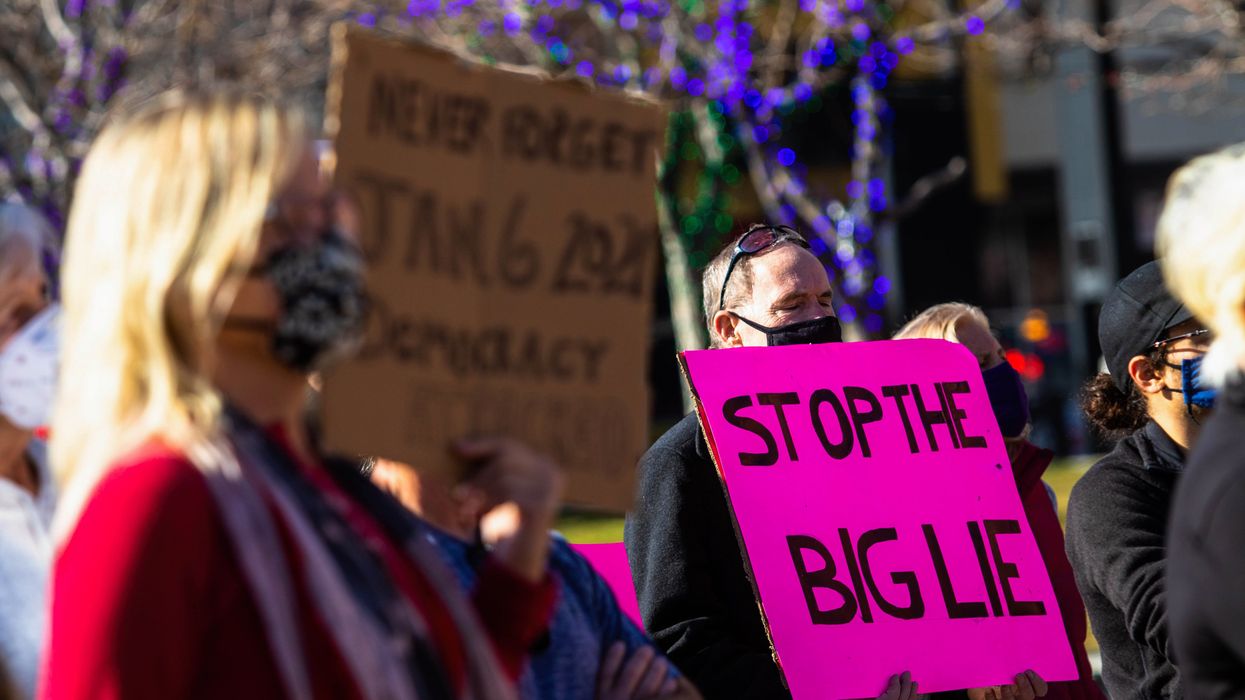 Man holding a sign that reads, "Stop the Big Lie"