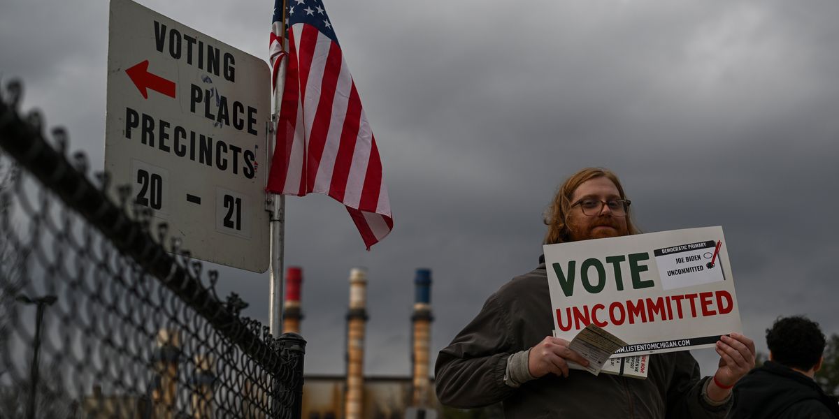 Man holding a sign that reads, "Vote Uncommitted"