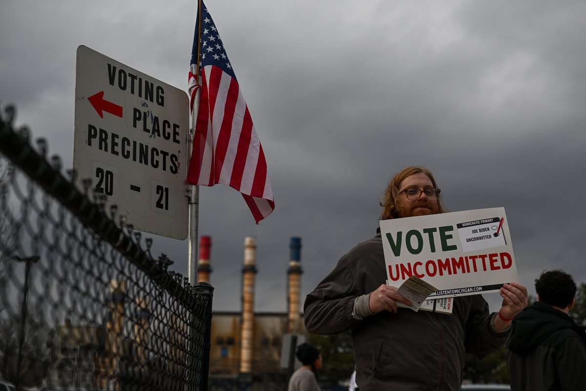 Man holding a sign that reads, "Vote Uncommitted"