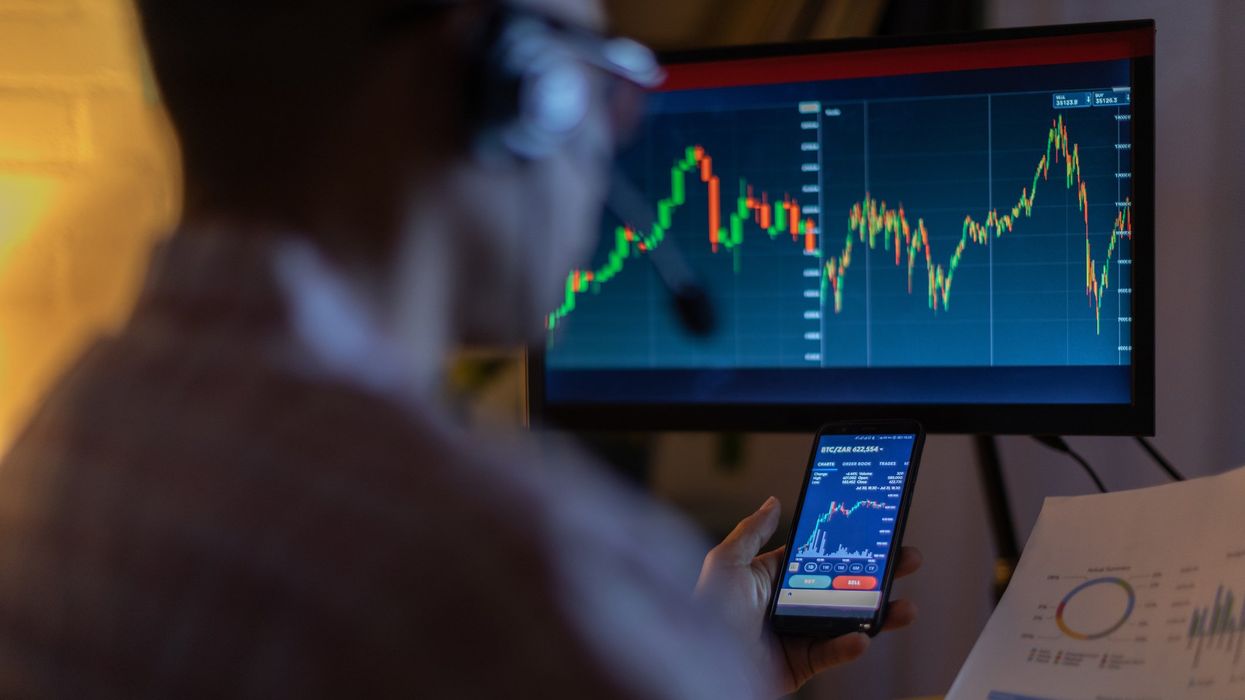 Man looking at stocks on his phone. Stock market.