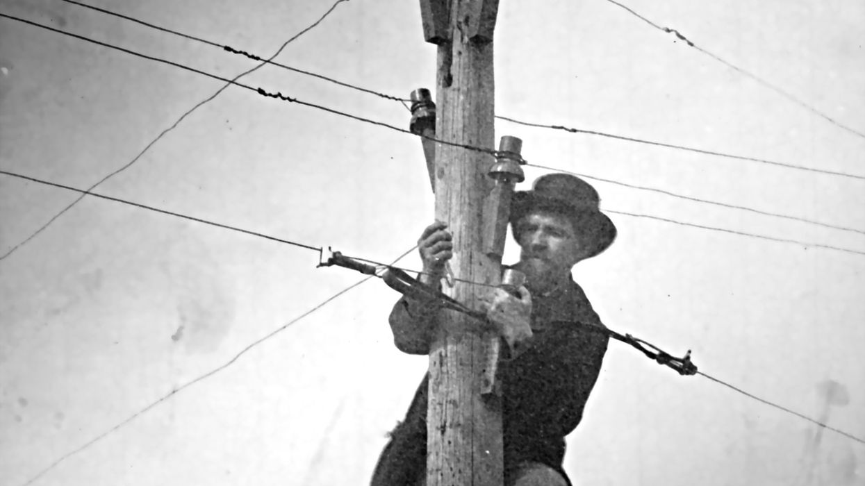 Man maintaining telegraph wire