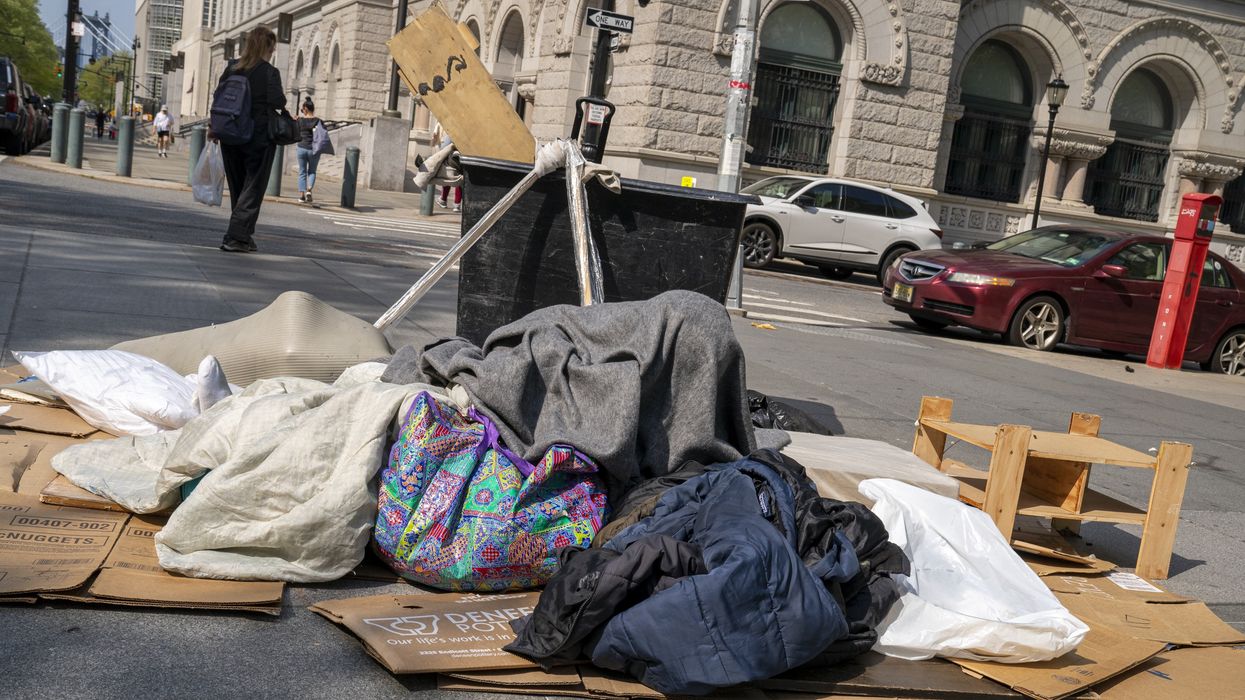 Man spreading bags and blankets over cardboard boxes