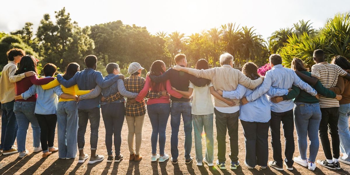 Many people standing arm-in-arm