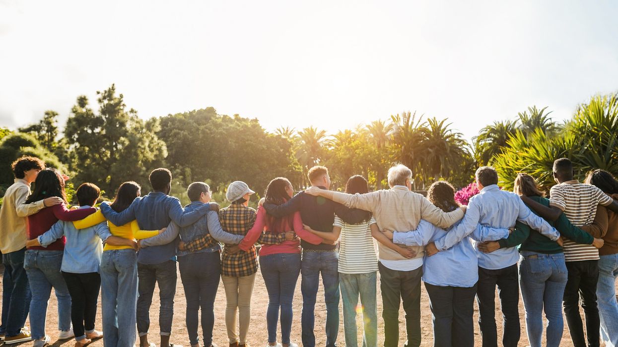 Many people standing arm-in-arm