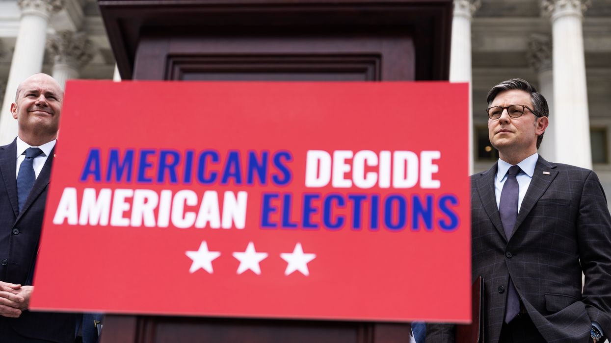Members of Congress standing next to a sign that reads "Americans Decide American Elections"