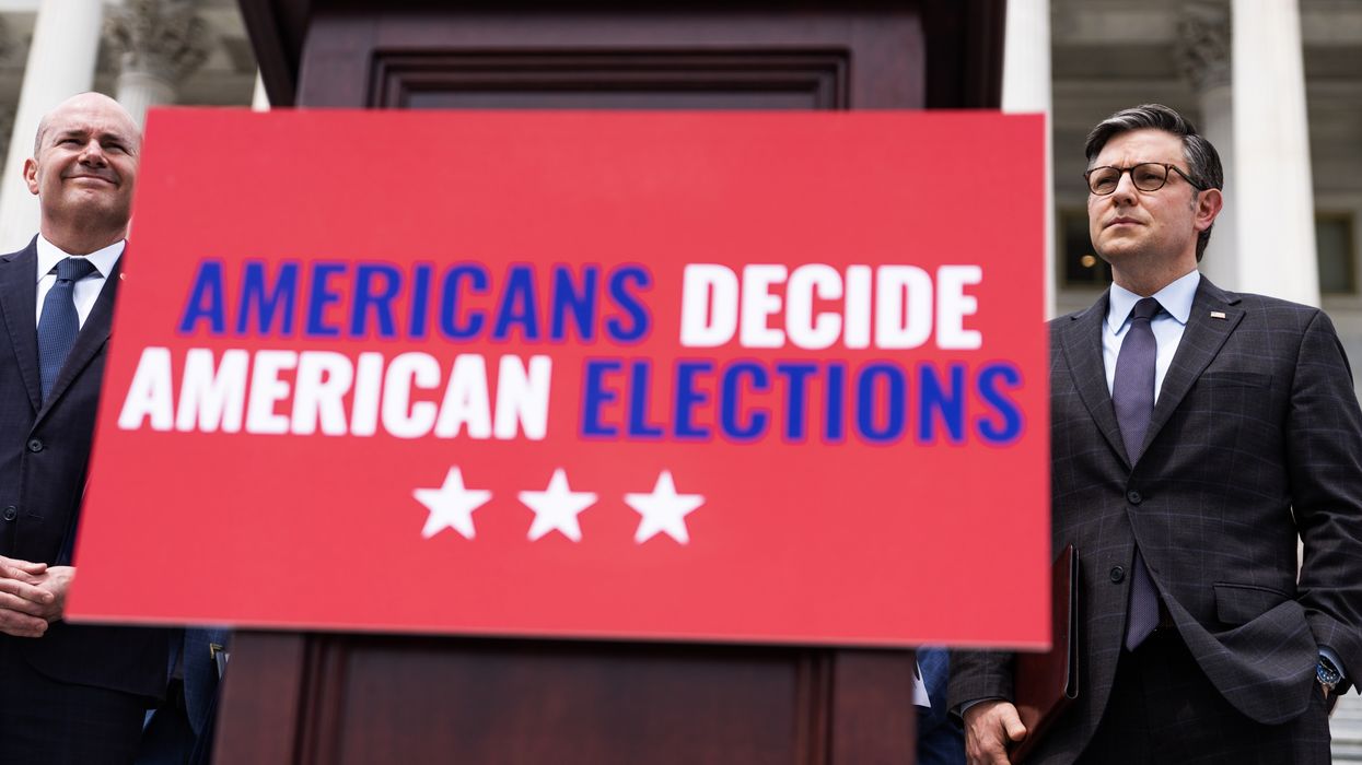 Members of Congress standing next to a sign that reads "Americans Decide American Elections"