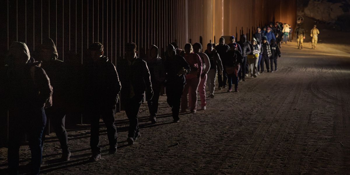 Migrants walking along the border