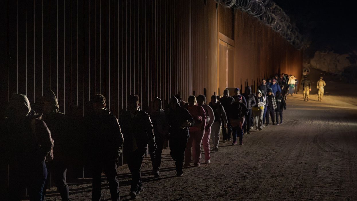 Migrants walking along the border