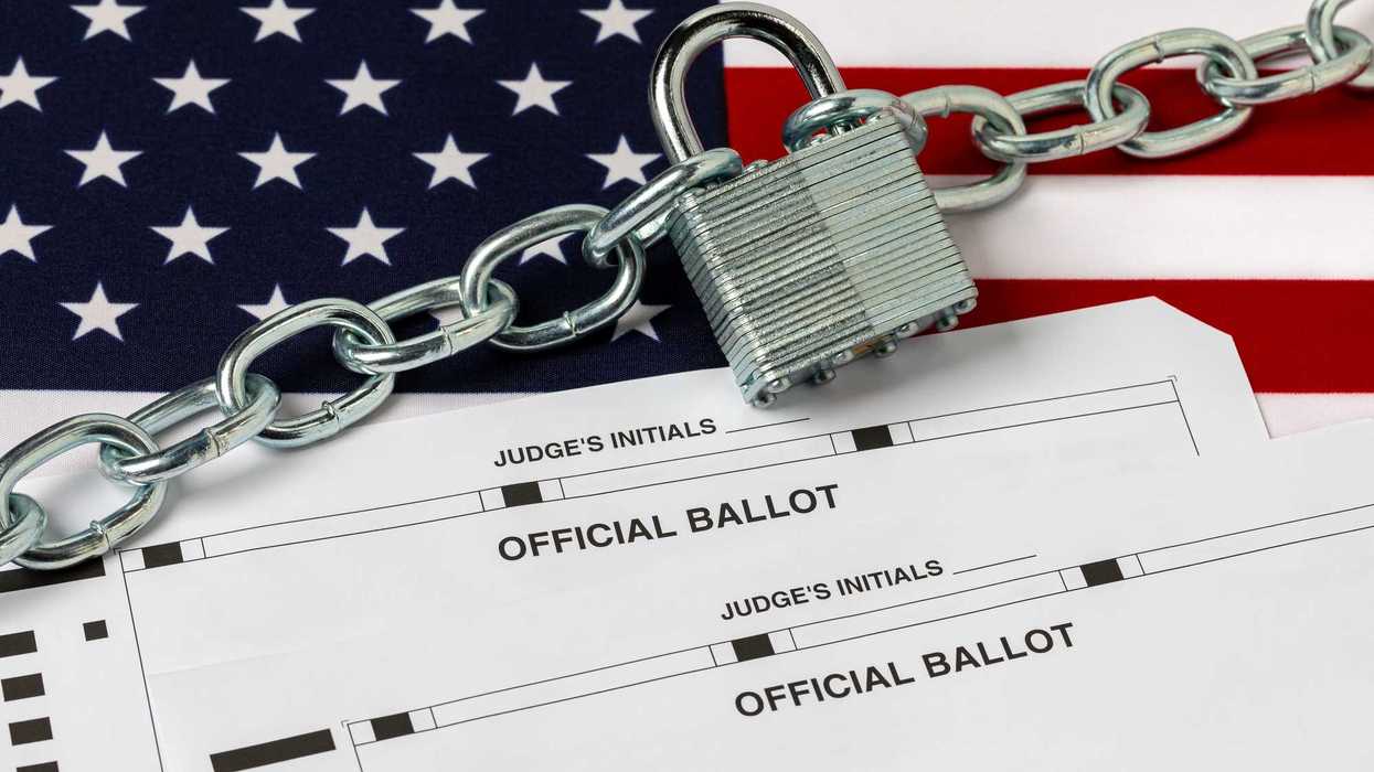 Official ballots with a chain and lock over them, and the USA flag behind them.