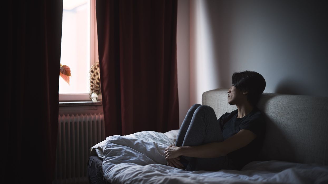 Pensive man sitting on sofa and looking through window