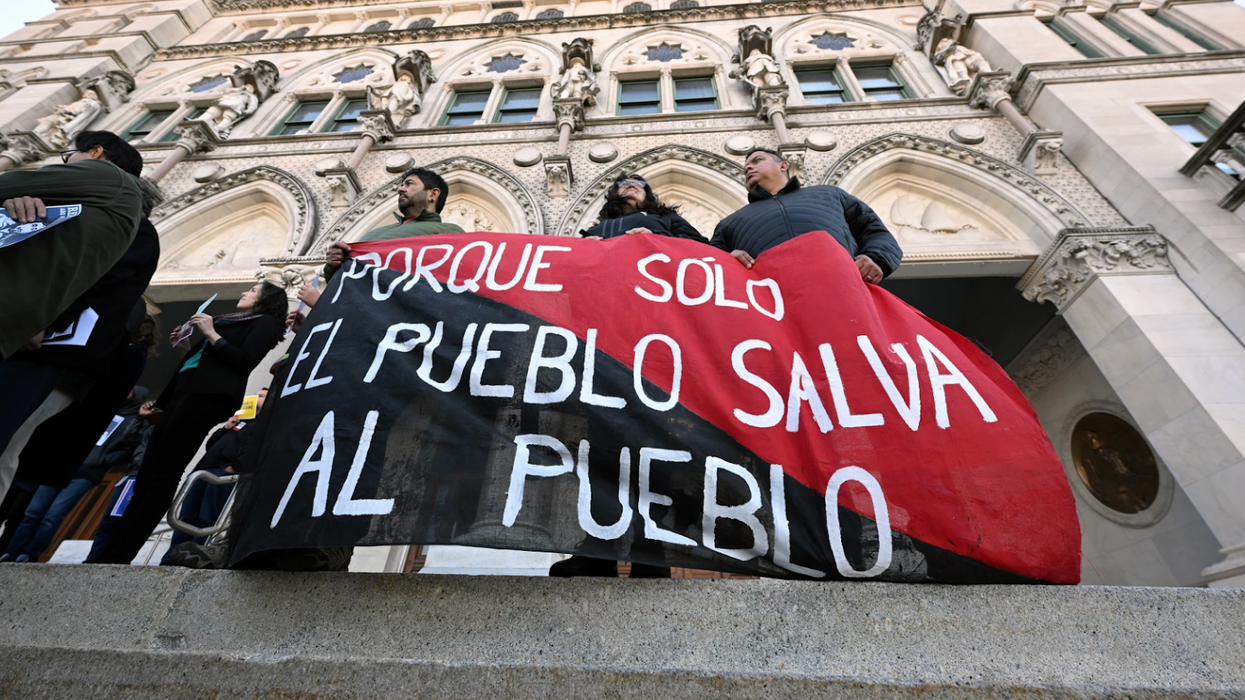 People holding a sign in Spanish