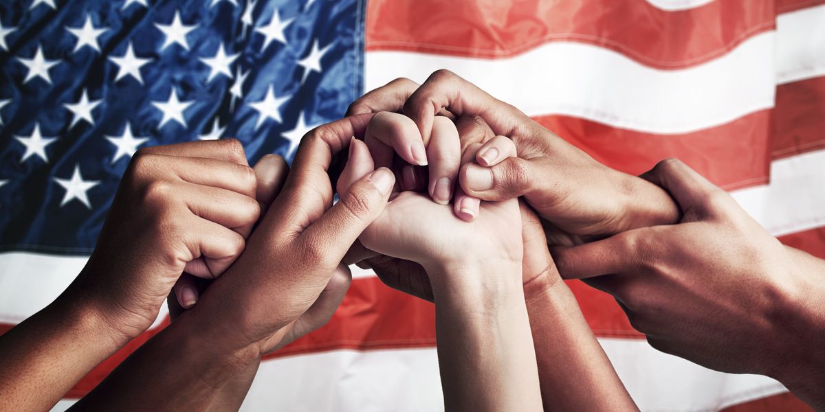 People holding hands in front of an American flag