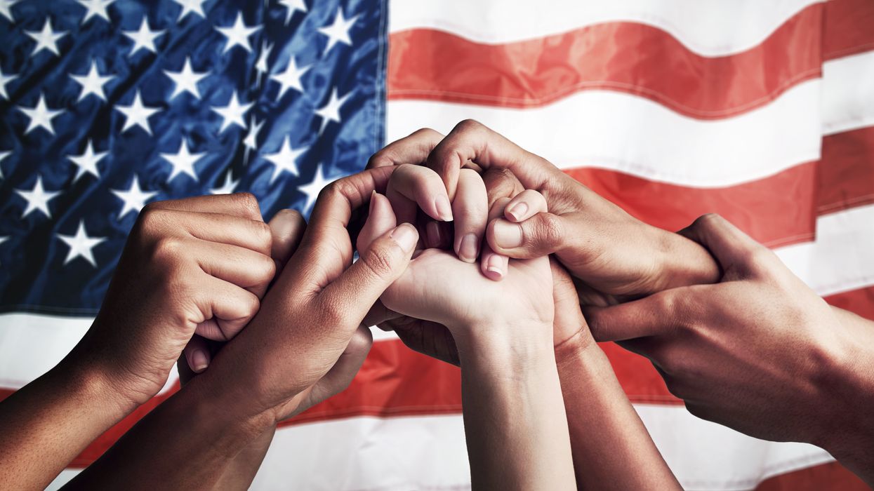 People holding hands in front of an American flag