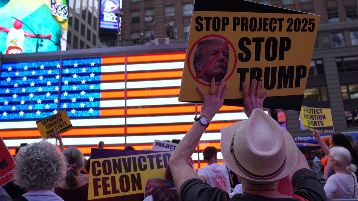 People holding signs against Project 2025 and Donald Trump