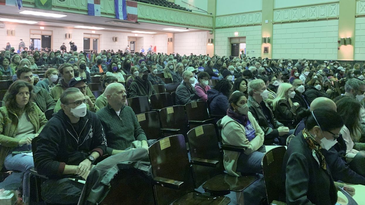 People in chairs in a school auditorium
