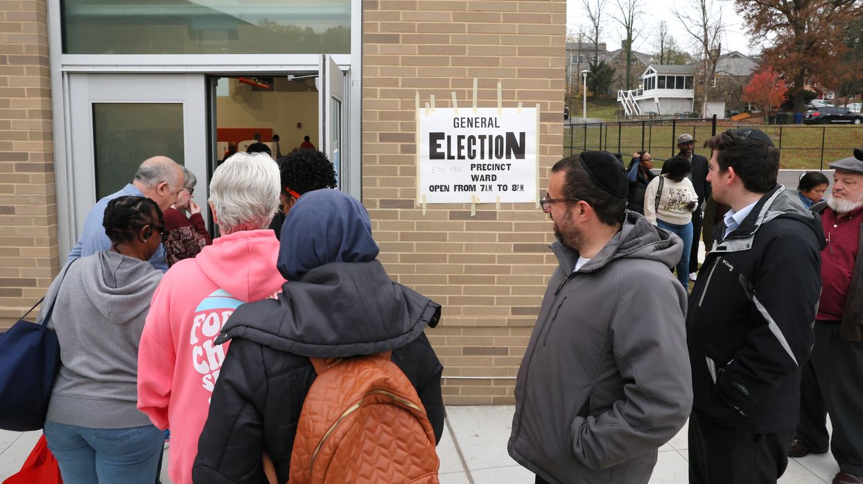 People in line outside a building that has a sign that reads "General election"