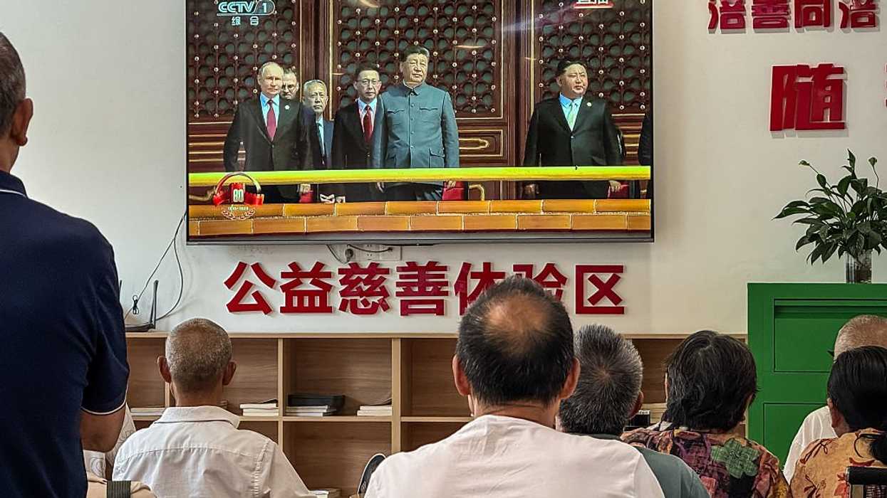 People looking at a TV screen, live broadcasting China's Victory Day military parade from Beijing on September 3, 2025 in Chongqing, China.