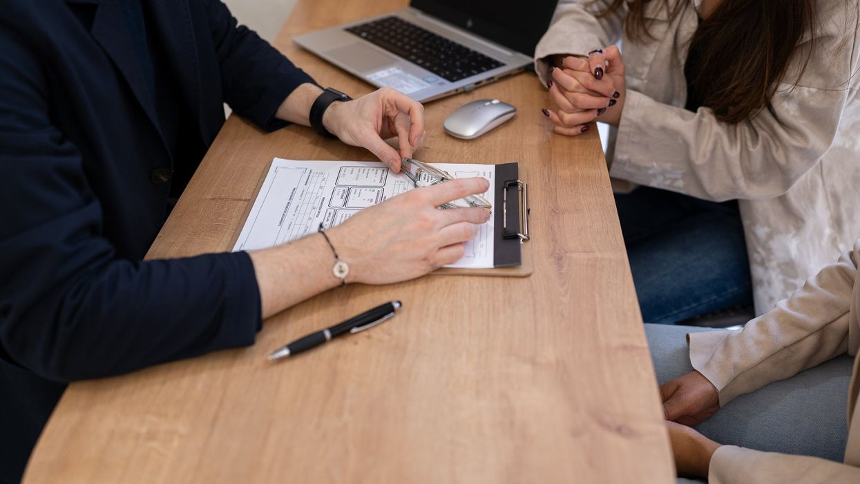 People meeting with advisor, caseworker. Paperwork. Meeting.