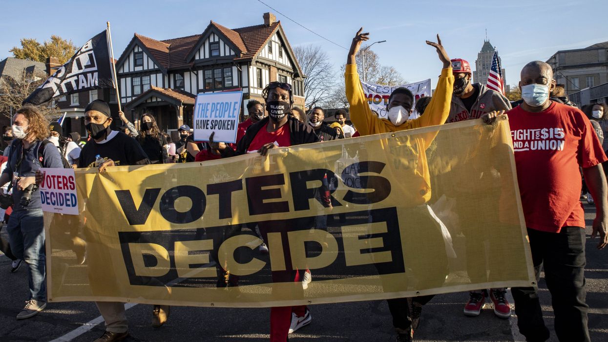 People protesting with a large banner that reads "Voters Decide"