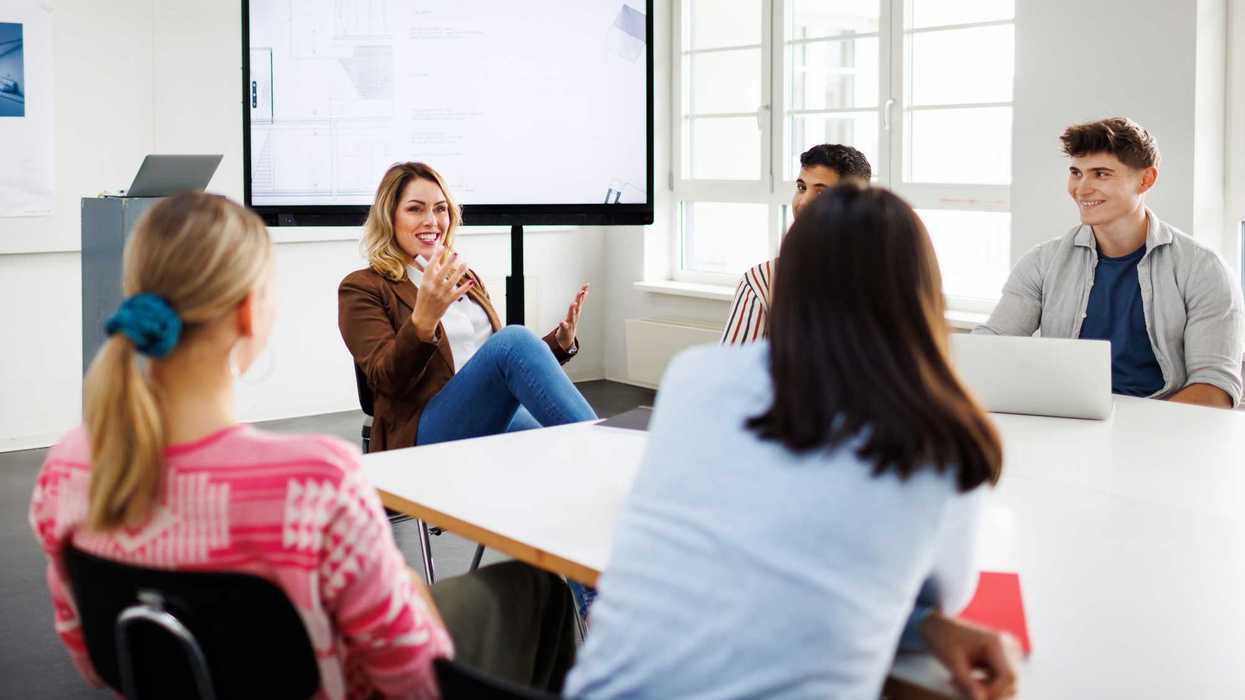 People siting around a table in a classroom.