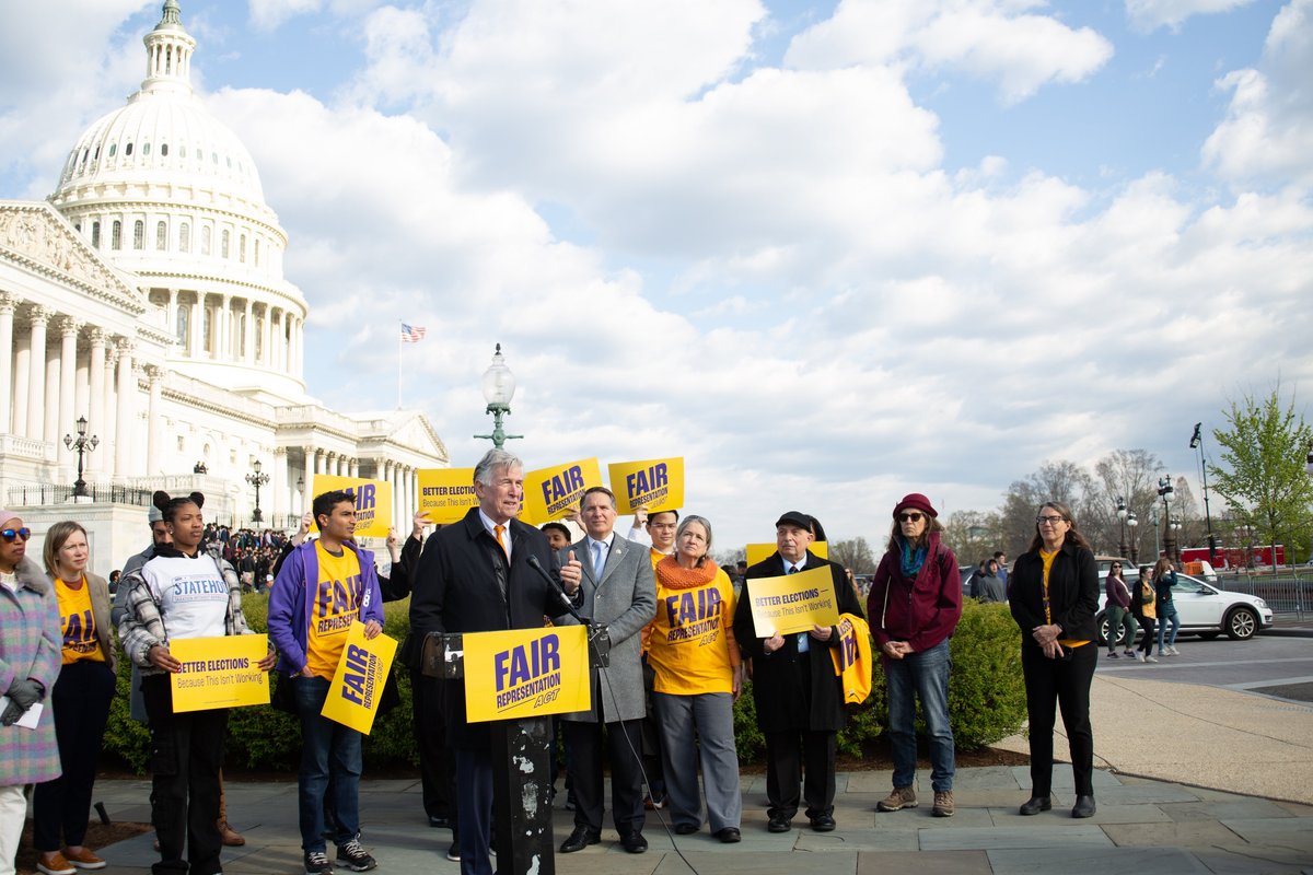 People speaking in front of the Capitol