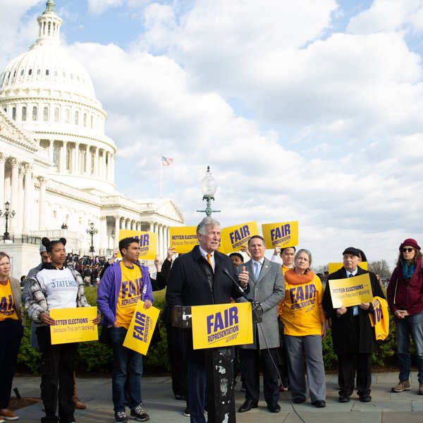 People speaking in front of the Capitol