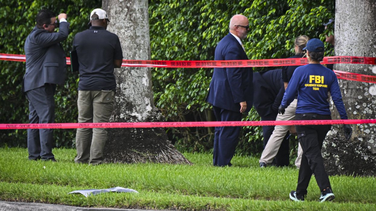 People working in a taped off area near trees